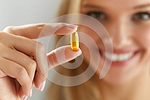 Beautiful Woman Holding Fish Oil Pill In Hand. Healthy Nutrition