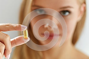 Beautiful Woman Holding Fish Oil Pill In Hand. Healthy Nutrition