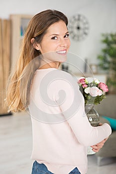 Beautiful woman holding flower vase