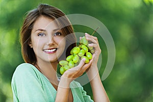 Beautiful woman holding grapes