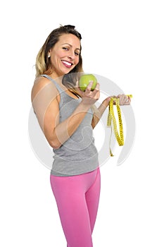 beautiful woman holding green apple fruit and measure tape in healthy nutrition diet and fitness concept