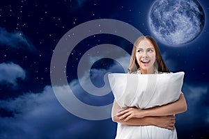 Beautiful woman holding pillow and night sky with full moon on background. Bedtime