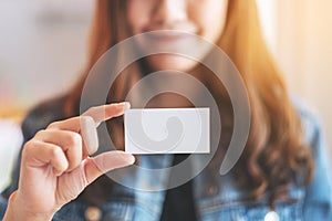 A beautiful woman holding and showing a blank empty business card