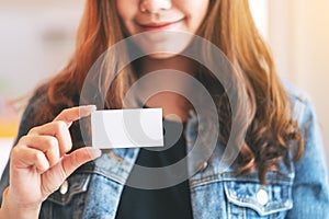 A beautiful woman holding and showing a blank empty business card