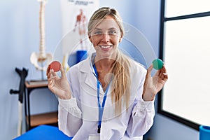 Beautiful woman holding strength ball for hand rehabilitation smiling with a happy and cool smile on face
