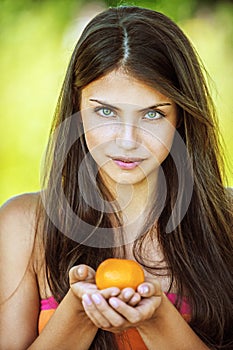 Beautiful woman holding tangerine