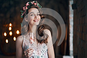 Beautiful woman holding wineglass with rose petals