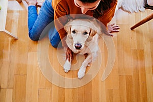 beautiful woman hugging her adorable golden retriever dog at home. love for animals concept. lifestyle indoors