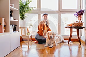 beautiful woman hugging her adorable golden retriever dog at home. love for animals concept. lifestyle indoors