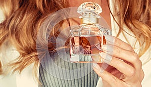 Beautiful woman i with perfume. Perfume bottle in beautiful woman hands. Woman with bottle of perfume. Perfume bottle