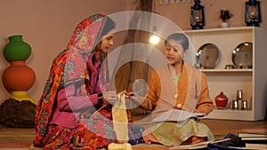 A beautiful woman of an Indian village knitting clothes using a knitting yarn - Village home in India