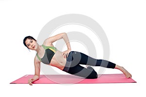 Beautiful woman indoor exercising using pink yoga mat