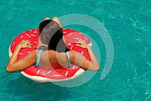 Beautiful woman and inflatable swim ring in shape of donut