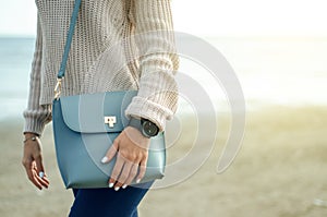 Beautiful woman in a jeans sweater shoes female bag watch