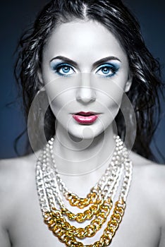 Beautiful woman with jewelry and beauty blue make up.