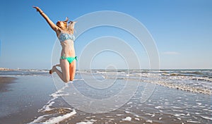 Beautiful woman jump on the beach in the sea