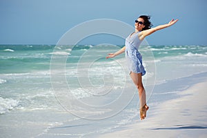 Beautiful woman jumping on the Beach. Vacation Concept photo