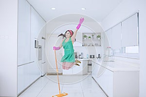 Beautiful woman jumping happily while mopping