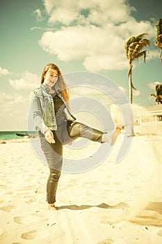 Beautiful woman kick sand on the beach at bahamas