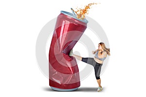 Beautiful woman kicking a can of soft drink