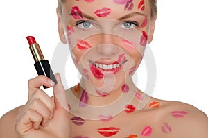 Beautiful woman with kisses on face and lipstick in hand