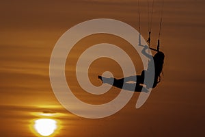 Beautiful woman kitesurfing jump at golden hour girl jumping kiteboarding silhouette at sunset