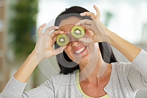 Beautiful woman with kiwi fruit on eyes