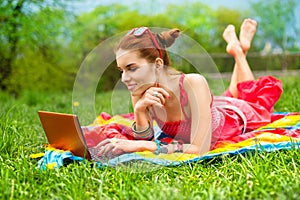 Beautiful woman with laptop on grass