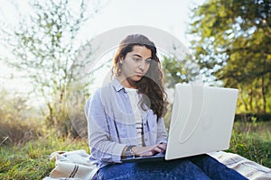 Beautiful woman with laptop on the grass