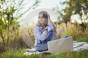 Beautiful woman with laptop on the grass