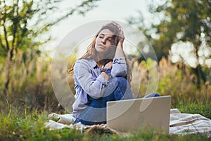 Beautiful woman with laptop on the grass