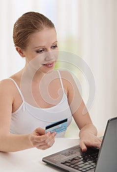 Beautiful woman with laptop makes payment online