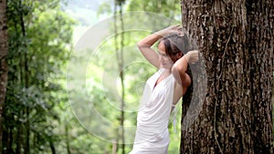 Beautiful woman lean on tree trunk in forest posing to camera. 1920x1080, hd