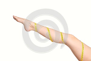 Beautiful woman leg with a coiled measure tape