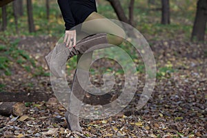 Beautiful woman legs in suede boots in autumn forest