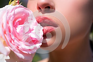 Beautiful woman lips with rose. Natural lip makeup. Closeup beautiful female mouth. Plump full lips.