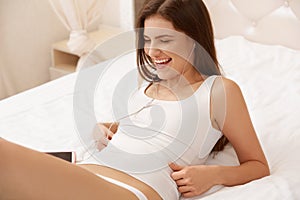 Beautiful Woman Listens a Music lying on the bed