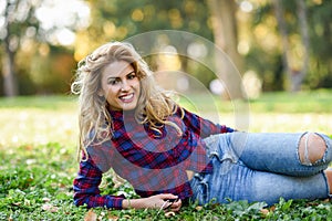 Beautiful woman with long blond curly hair in a park