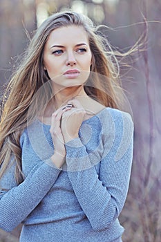 Beautiful woman with long blond hair. Close up portrait of a fashion model posing outdoor