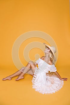 Beautiful woman with long blond hair, wearing a white dress and hat.