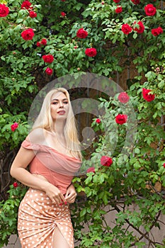 Beautiful woman with long blonde hair and red lips wearing pink clothes