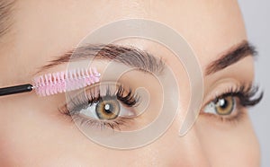 Beautiful Woman with long eyelashes in a beauty salon. Eyelash extension procedure. Cosmetology skin care