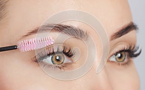 Beautiful Woman with long eyelashes in a beauty salon. Eyelash extension procedure. Cosmetology skin care photo