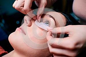 Beautiful Woman with long eyelashes in a beauty salon. Eyelash extension procedure. Lashes close up