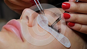 Beautiful woman with long eyelashes in a beauty salon. Eyelash extension procedure. Lashes close up