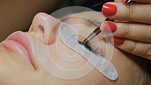 Beautiful Woman with long eyelashes in a beauty salon. Eyelash extension procedure. Lashes close up
