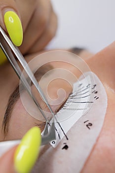 Beautiful Woman with long eyelashes in a beauty salon. Eyelash extension procedure. Lashes close up.