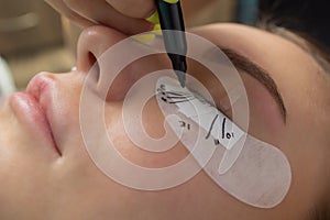 Beautiful Woman with long eyelashes in a beauty salon. Eyelash extension procedure. Lashes close up.