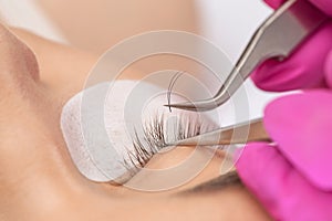 Beautiful Woman with long eyelashes in a beauty salon. Eyelash extension procedure. Lashes close up