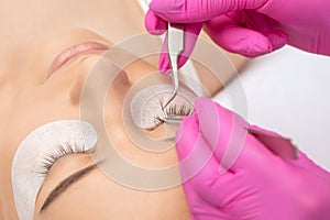 Beautiful Woman with long eyelashes in a beauty salon. Eyelash extension procedure. Lashes close up